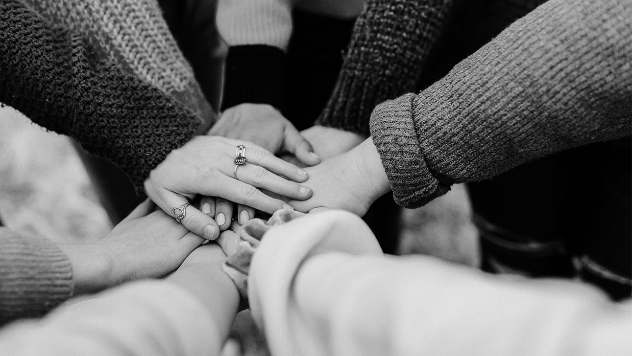 Hands extended into the center of a circle. Symbolizes cooperation.